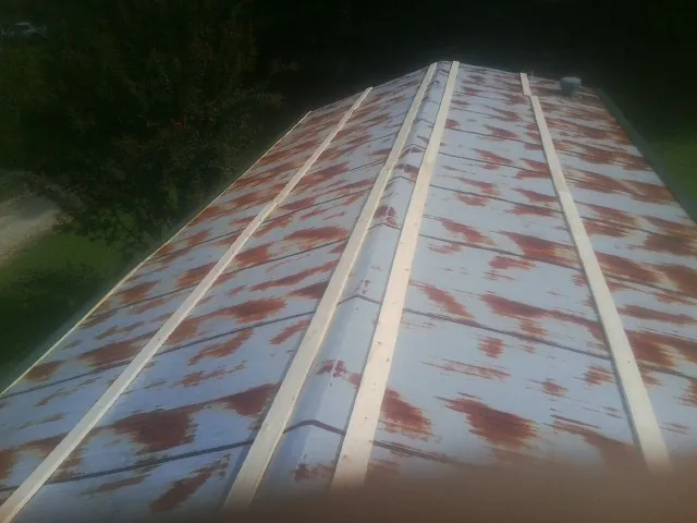 Rusted metal roof panels with new wood purlins before replacement — Storm Damage Roof Repair in Chesterland by Roofing Brothers