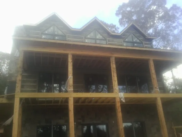 Dormers and porch framing on a large log home under construction — Roof Coating work by our crew in Chesterland